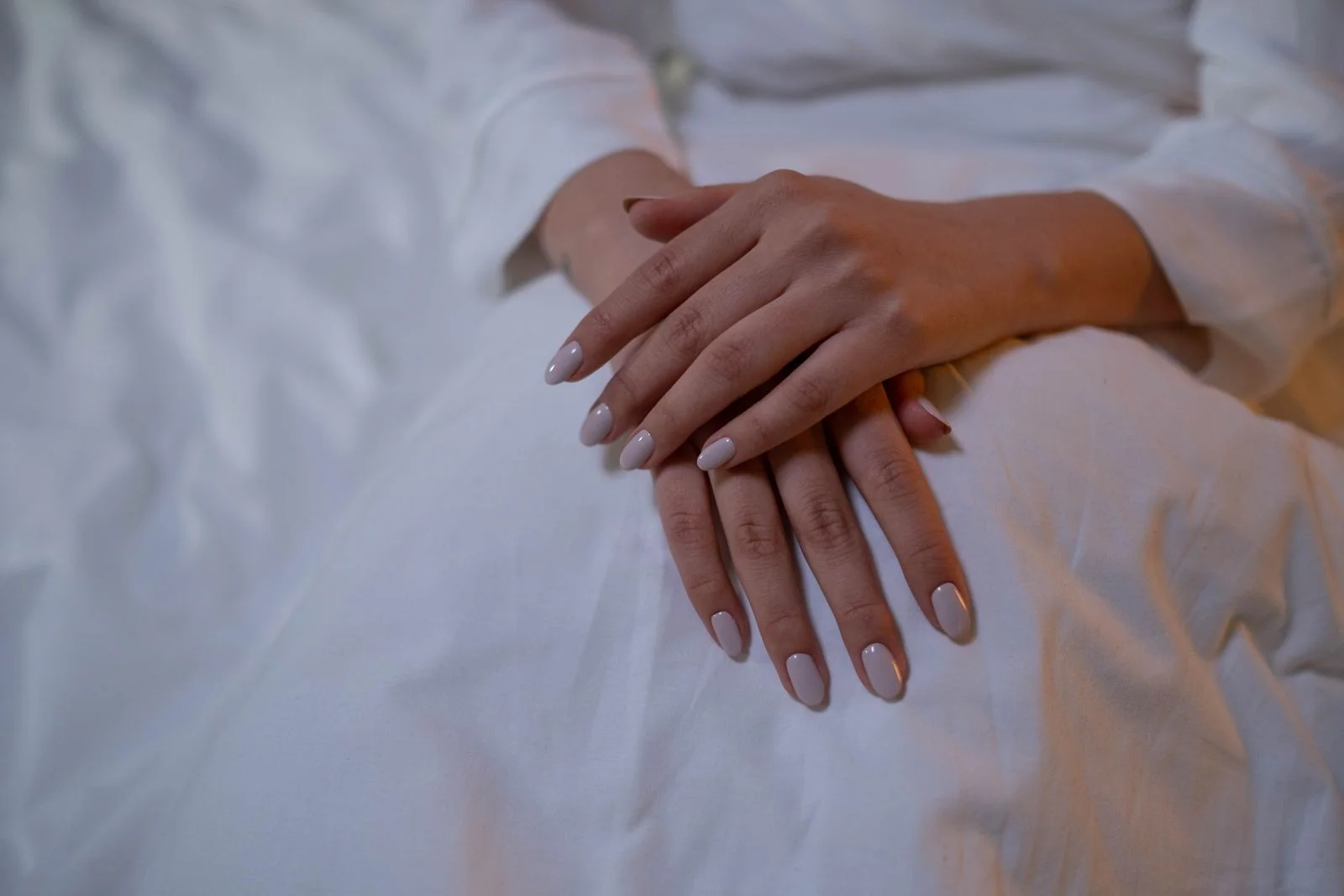 Understated nude nails on white linen